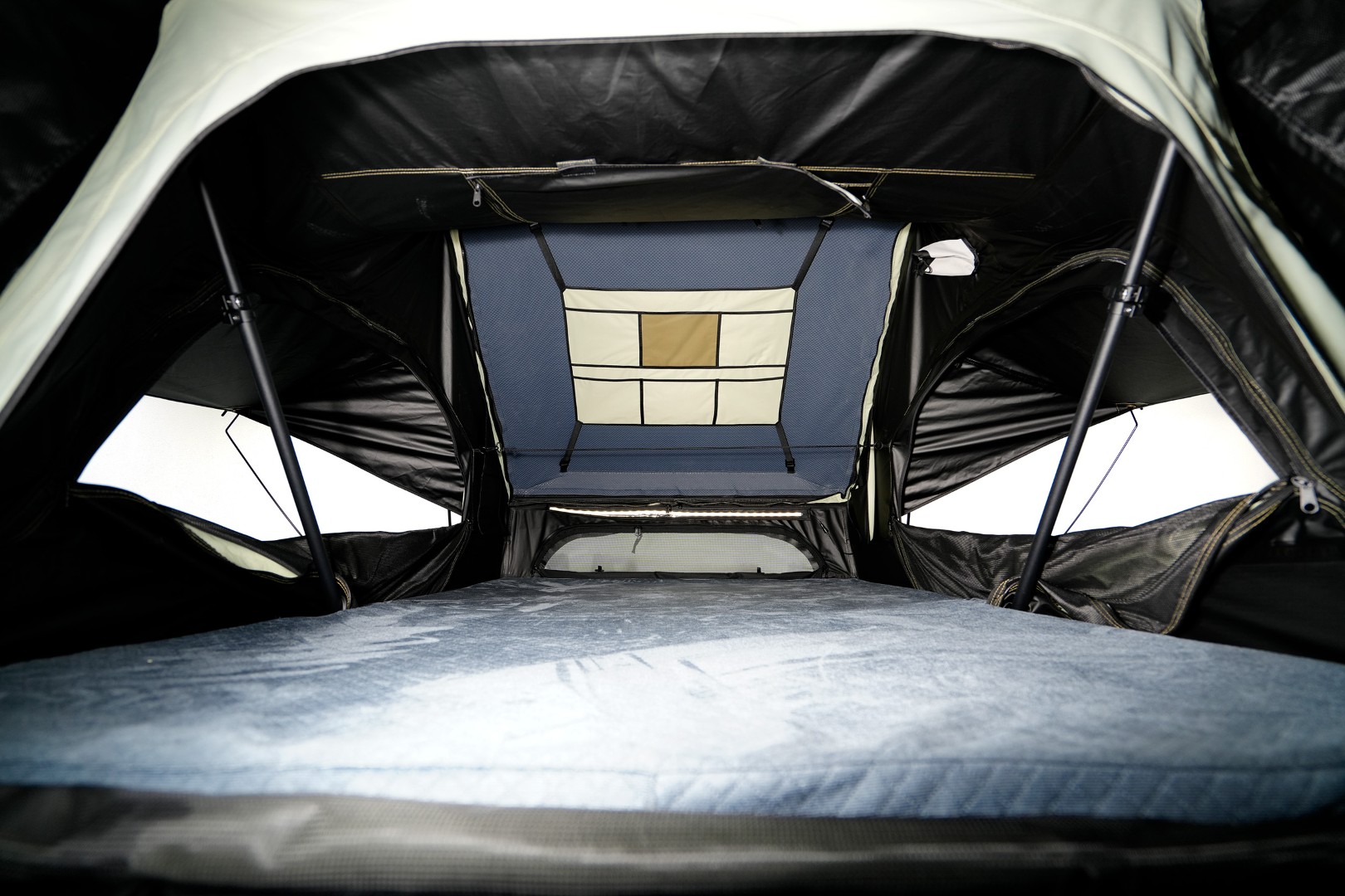 Inside of the Fjällvila UppVärme rooftop tent with storage pockets